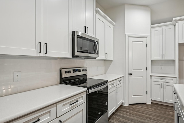 kitchen with white cabinetry, appliances with stainless steel finishes, and dark hardwood / wood-style floors