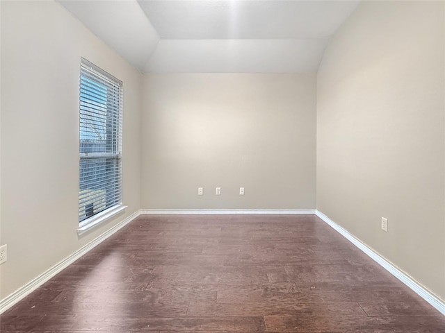 unfurnished room with vaulted ceiling and dark hardwood / wood-style flooring