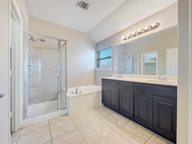 bathroom featuring tile patterned flooring, vaulted ceiling, shower with separate bathtub, and vanity