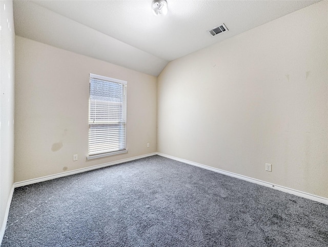 carpeted spare room featuring lofted ceiling