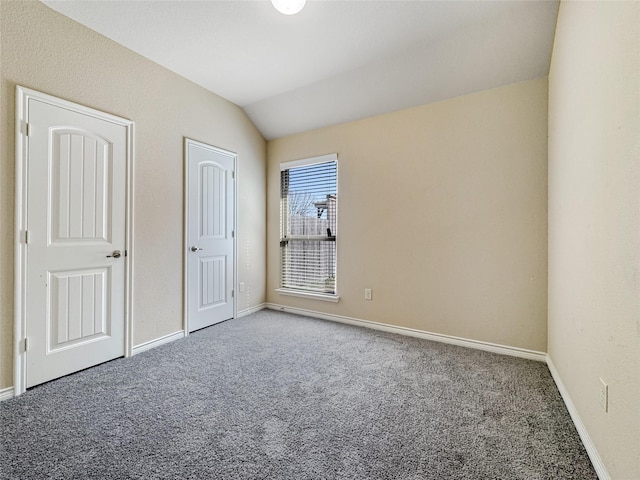 unfurnished bedroom with vaulted ceiling and carpet