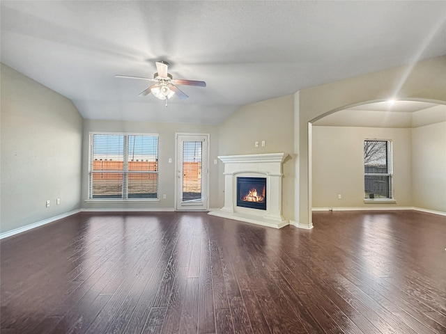 unfurnished living room with vaulted ceiling, dark hardwood / wood-style floors, and ceiling fan