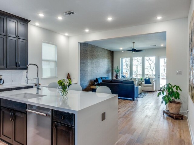 kitchen with a ceiling fan, visible vents, a sink, light countertops, and light wood-type flooring