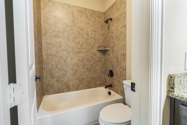 bathroom featuring tiled shower / bath and toilet