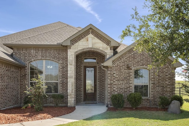 view of exterior entry featuring a yard