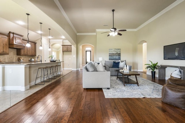 living room featuring ceiling fan, ornamental molding, and dark hardwood / wood-style floors