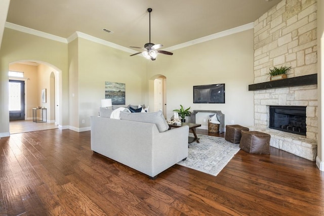 living room with dark hardwood / wood-style flooring, crown molding, a fireplace, and ceiling fan