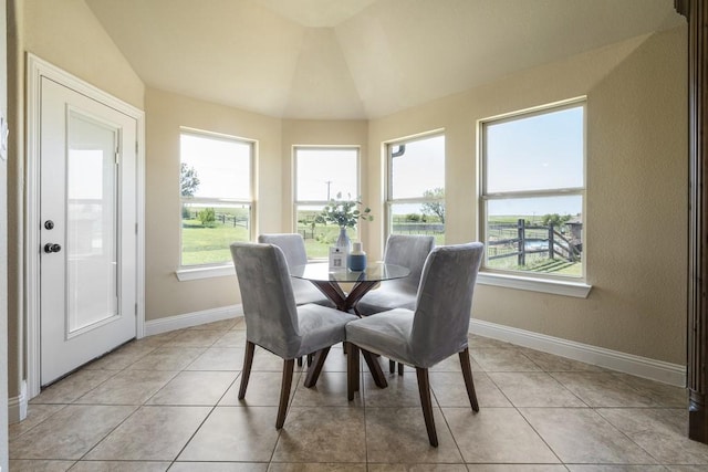 dining room with lofted ceiling and light tile patterned floors