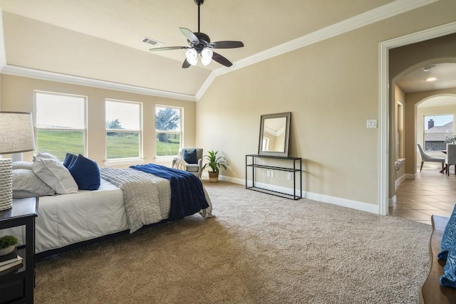 carpeted bedroom featuring ceiling fan, lofted ceiling, ornamental molding, and multiple windows