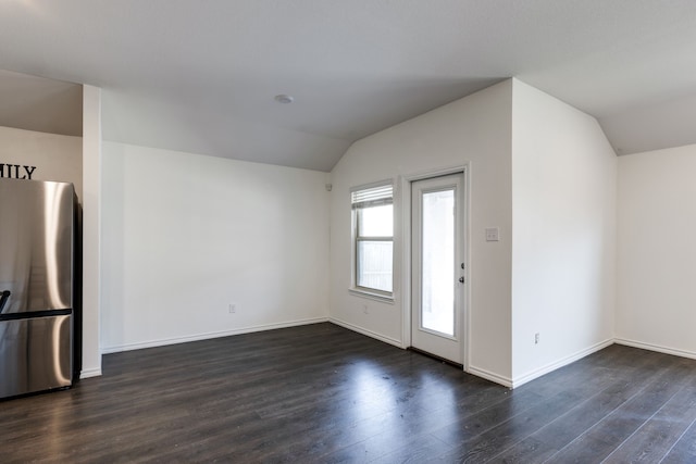 foyer entrance with dark wood-type flooring and vaulted ceiling