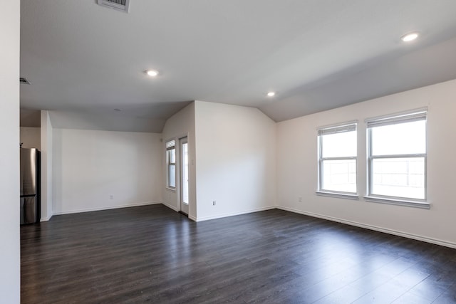 unfurnished room with vaulted ceiling and dark wood-type flooring