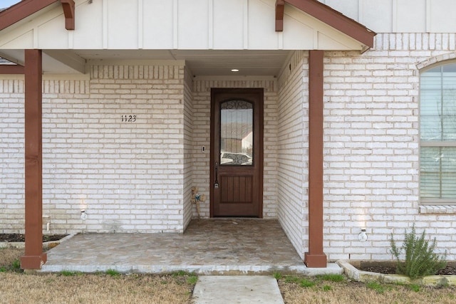 view of exterior entry with a patio