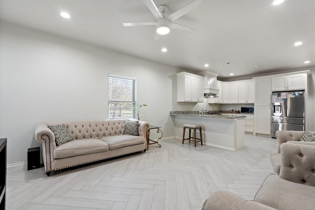 living room with ceiling fan, sink, and light parquet floors