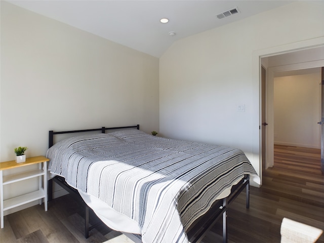 bedroom with vaulted ceiling and dark hardwood / wood-style flooring