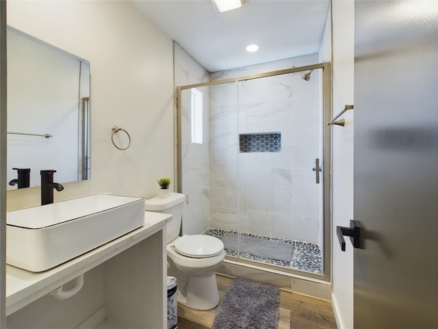 bathroom featuring toilet, a shower stall, wood finished floors, and vanity