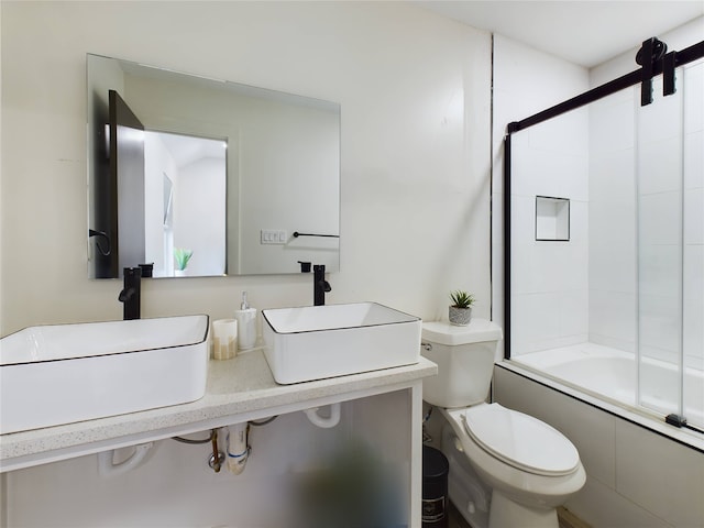 full bathroom featuring shower / bath combination with glass door, a sink, and toilet