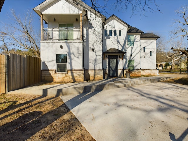 view of front of home with a balcony and fence