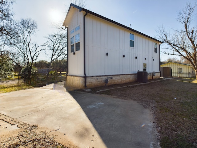 view of side of home with a patio area, central AC, and fence