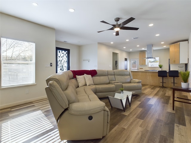 living room with a ceiling fan, baseboards, wood finished floors, and recessed lighting