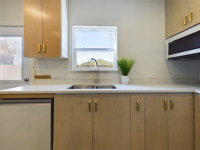 kitchen with white microwave, light countertops, and a sink