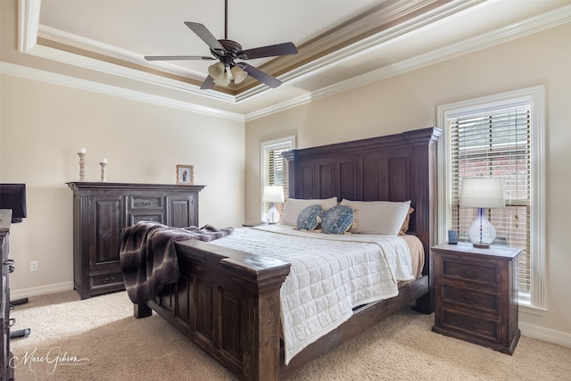 carpeted bedroom with crown molding, ceiling fan, and a tray ceiling