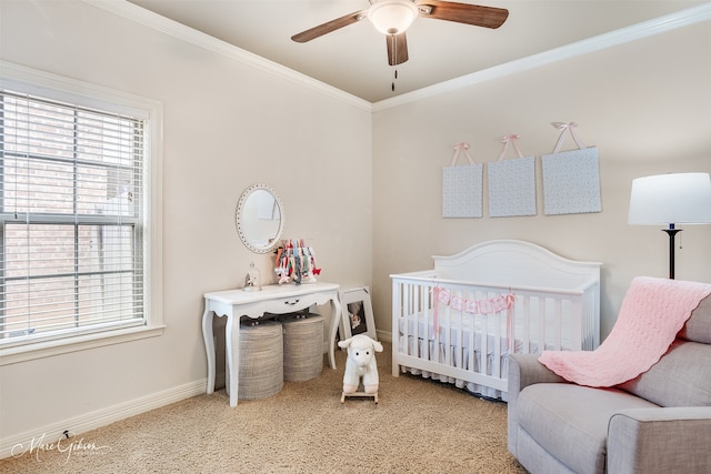 bedroom with ornamental molding, a nursery area, carpet, and ceiling fan