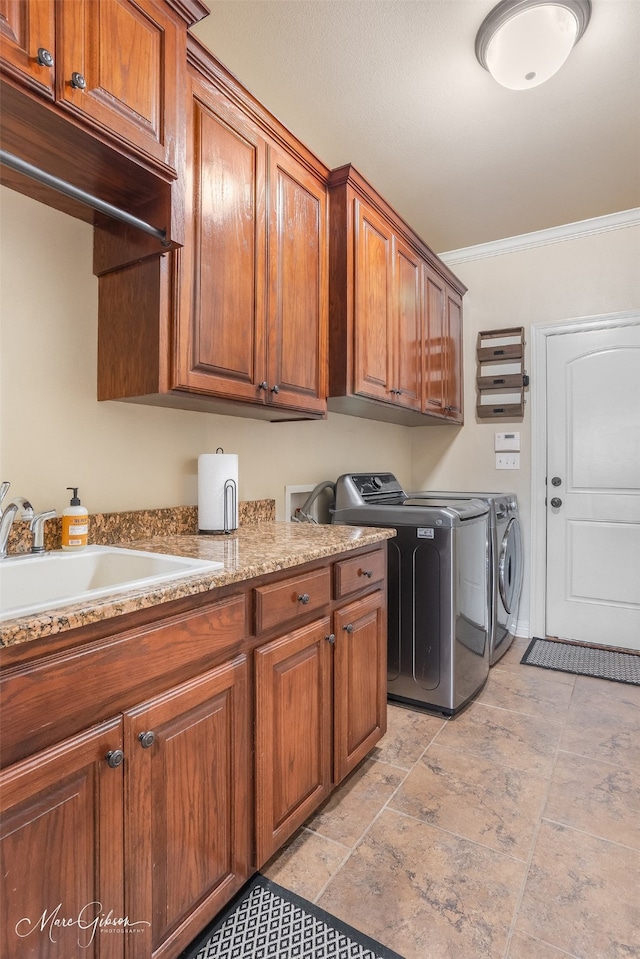 washroom with washer and dryer, sink, ornamental molding, and cabinets