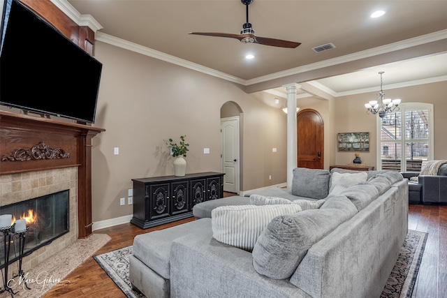 living room featuring ornamental molding, dark hardwood / wood-style flooring, and a tile fireplace