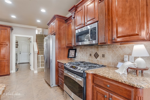 kitchen with ornamental molding, appliances with stainless steel finishes, backsplash, and light stone counters