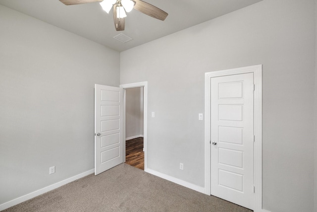 unfurnished room featuring ceiling fan and dark colored carpet