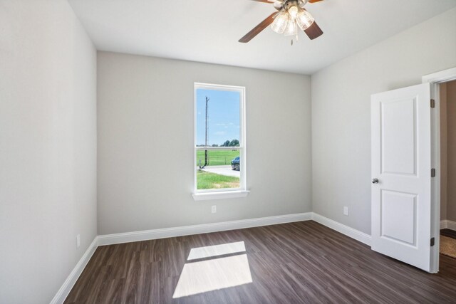 empty room featuring dark wood-type flooring and ceiling fan