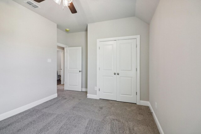 carpeted empty room featuring vaulted ceiling and ceiling fan