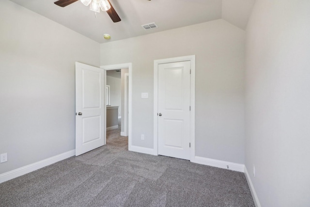 carpeted spare room with ceiling fan and vaulted ceiling