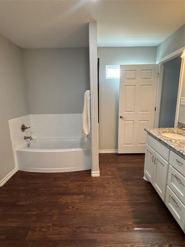 1006 High Point Dr, Mineral Wells, TX 76067 - full bath featuring wood finished floors, a garden tub, vanity, and baseboards