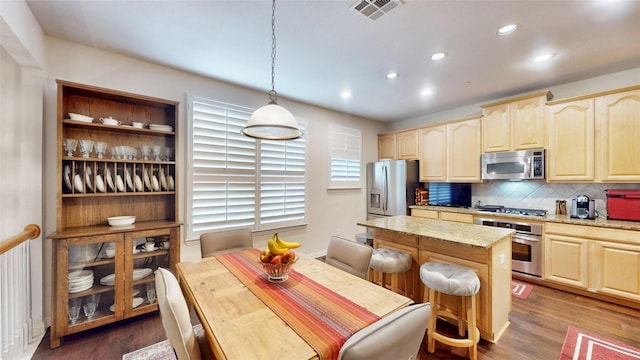 kitchen with pendant lighting, stainless steel appliances, light stone counters, dark hardwood / wood-style flooring, and decorative backsplash