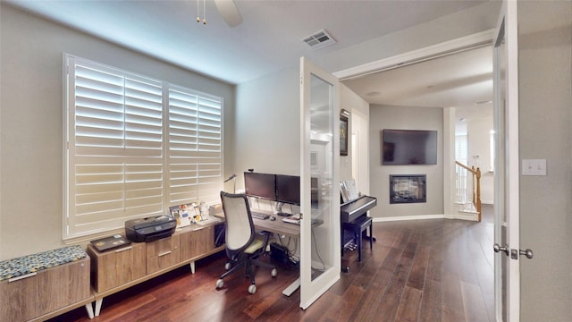 home office with ceiling fan, a healthy amount of sunlight, and dark hardwood / wood-style flooring