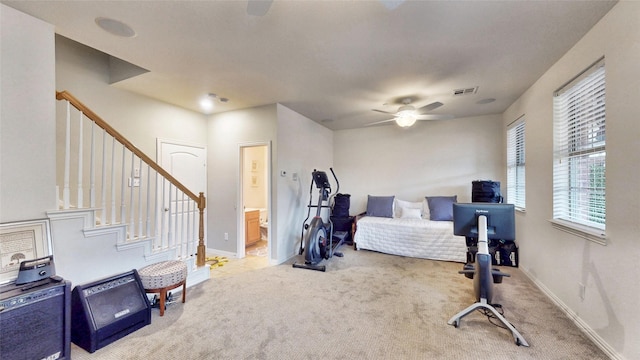 bedroom featuring connected bathroom, light colored carpet, and ceiling fan