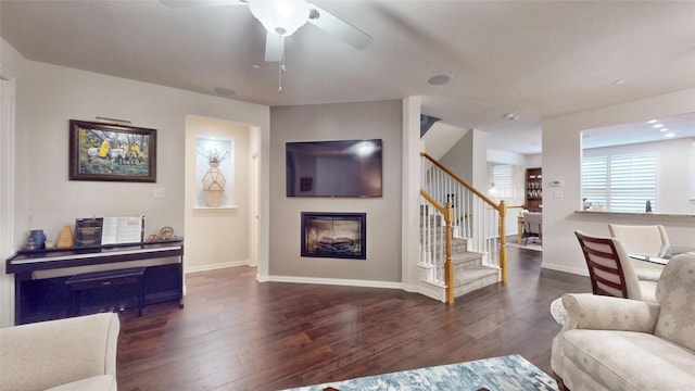 living room with dark wood-type flooring and ceiling fan