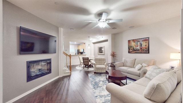 living room featuring ceiling fan and dark hardwood / wood-style floors