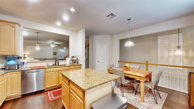 kitchen featuring pendant lighting, sink, stainless steel dishwasher, and light brown cabinetry