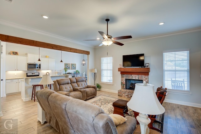 living room with ornamental molding, a healthy amount of sunlight, and light wood-type flooring