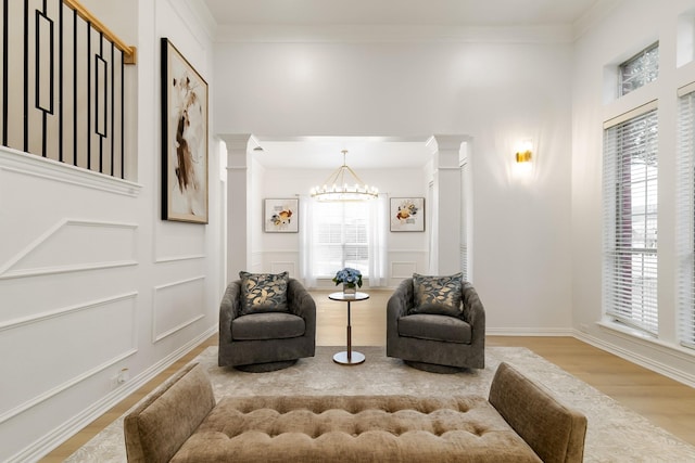 living area with crown molding, a chandelier, and a wealth of natural light