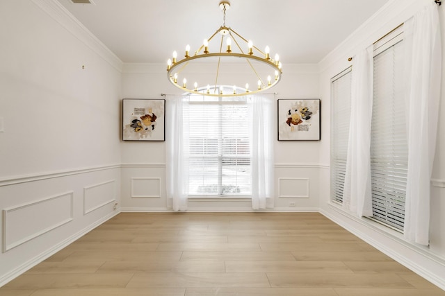 unfurnished dining area featuring crown molding, light hardwood / wood-style floors, and a notable chandelier