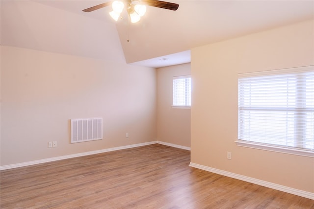 unfurnished room with ceiling fan, lofted ceiling, and light wood-type flooring