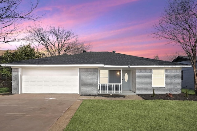 single story home with a garage, covered porch, and a lawn