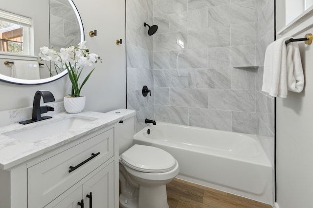 full bathroom with vanity, wood-type flooring, toilet, and tiled shower / bath