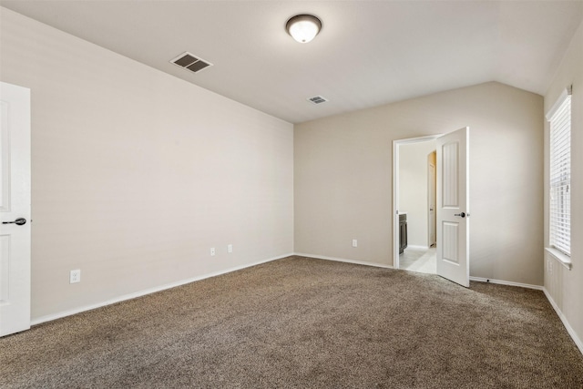 unfurnished bedroom featuring multiple windows, lofted ceiling, and carpet flooring