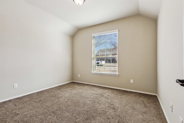 carpeted empty room featuring vaulted ceiling