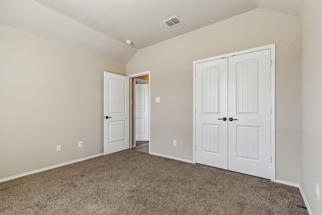 unfurnished bedroom featuring lofted ceiling, carpet floors, and a closet