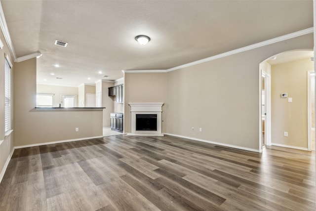 unfurnished living room with crown molding and hardwood / wood-style flooring